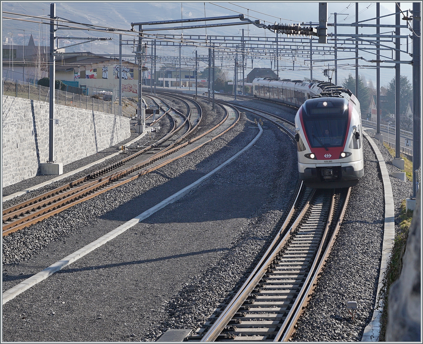 Um den RER Vaud S-Bahnen ein wenden in Cully zu ermöglichen hat man den Bahnhof umgebaut: das Bergseitige Gleis im Einfahrbereich etwa gestreckt und gegen den Berg verschoben, das ehemalige Durchfahrgleis hat nun Seite Lausanne Weichenverbidnungen ohne den Gengenverkehr zu beeinträchtigen und as ehemalige Überholgeleis ist nun das Durchfahrtgleis Richtung Lausanne. 

Im Bild Zwei SBB RABe 523 auf dem Weg in Richtung Lausanne. Dieser Zug kommt von Aigle, nutze also das Gleis 3. 

20. Feb. 2023