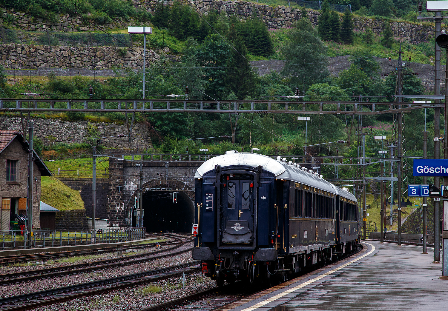 Und tschüs, nun fährt der VSOE - Venice Simplon-Orient-Express von Amsterdam über Brüssel und Paris nach Venedig, am 02.08.2019, vom Bahnhof Göschenen ins Nordportal des 15 km langen Gotthard-Scheiteltunnel ein und weiter in Richtung Chiasso. Bevor es weiter nach Italien und dem Ziel Venedig geht, werden in Chiasso die Loks gewechselt, die Vorräte aufgefüllt und Schmutzwasser abgelassen. 

Hier am Zugschluss der VSOE Schlafwagen Nr. 3425 – VSOE Sleeping-Car / Voiture-Lits / Carrozza-Letti N° 3425 (F- VSOE 61 87 76-70 425-5), einer der beiden  Grand Suite -Wagen (mit seinen drei Suiten „Paris, Istanbul und Venedig), ein ehemaliger CIWL Type S1-Wagen. 

Der Wagen wurde 1929 von der Birmingham Railway Carriage and Wagon Company (BRC&W) als gebaut und als Schlafwagen (WL) vom Typ S1 an die CIWL geliefert die ihn als Nr. 3425 bezeichnete. Die S1-Wagen hatten ursprünglich 17 Betten, 9 in Einzel- und 4 in Zweibett-Abteile. Ende der 1970er Jahre wurde der Wagen an die VSOE verkauft. Im März 2018 wurde bei der VSOE mit der Umrüstung des S1-Schlafwagens Nr. 3425 die Klasse Grand Suite eingeführt. Die drei Suiten (Paris, Istanbul und Venedig) verfügen über Doppel- oder Einzelbetten sowie einen Salon mit Sofa (das in ein drittes Bett umgewandelt werden kann) und ein eigenes Bad. Einfach purer Luxus. 

TECHNIK:
Der Wagenkasten bestand erstmals komplett aus Stahlprofilen und -blechen. Ebenso kam erstmalig ein standardisiertes Fahrgestell mit 23.452 mm Länge über Puffer und einem Drehzapfenabstand von 16.000 mm sowie neu konstruierte Schwanenhals-Drehgestelle mit Rollenlager zur Anwendung, welche für eine größere Laufruhe sorgten. Die Fahrzeugbreite betrug einheitlich 2.850 mm, die Höhe über Schienenoberkante wird mit 4.000 mm angegeben.

Auf diesem aus drei Längsträgern mit Querverbindungen und zwei Gussstahlblöcken zur Aufnahme der Zug- und Stoßvorrichtungen bestehenden Rahmen entstanden neben dem Typ S auch die Schlafwagen der Typen Lx, Y und Z sowie die ab 1922 beschafften Ganzstahl-Speisewagen und Pullmanwagen der CIWL.

Im Laufe der Jahre wurden die Drehgestelle modernisiert oder durch neuere Bauarten ersetzt. Ursprünglich waren die Waggons für 130 km/h zugelassen, nach dem Zweiten Weltkrieg konnte die Höchstgeschwindigkeit auf 140 km/h angehoben werden. Die mit neuen luftgeferderten Drehgestellen von Bombardier, zwischen 2003 bis 2006, ausgerüsteten Wagen des VSOE sind für maximal 160 km/h zugelassen.

Die Wagen waren standardmäßig mit einer Dampfheizung und einer davon unabhängigen Kohleheizung ausgestattet, welche durch den Schlafwagenschaffner bedient wurde. Der Heizkessel war an einem Wagenende stehend situiert und über die Plattform zugänglich. Später erhielten die Fahrzeuge zudem elektrische Heizungen.

Der Schlafwagenschaffner nächtigte auf einer an seinem Sitzplatz am Ende des Wagens befindlichen, aufklappbaren Liege im Gang. An beiden Wagenenden befanden sich Schränke für die zur Versorgung der Fahrgäste notwendigen Utensilien sowie jeweils ein WC.
