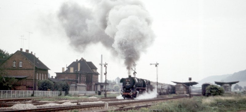 Am Morgen des 4. Juli 1980 hat eine Sangerh�user 44er mit ihrem Zementkessel-Leerzug in Laucha Ausfahrt aus Gleis 7 nach Karsdorf erhalten. Auf Gleis 9, am damals noch vorhandenen Bahnsteig 2, ist ein langer Sonderzug aus alten vierachsigen Schnellzugwagen abgestellt! (Foto: Klaus Pollm�cher)

