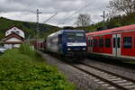 Mit einem Zug der S2 nach Kaiserslautern trifft sich RBH 145 055-0 samt ihrem leeren Autotransportwagons am 24.4.2025 in Neckargerach. 