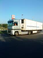 LKW SZM Renault mit Khlkofferauflieger beim Verlassen des Autohofes in Grnstadt am 04.09.2013