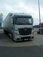 LKW SZM Mercedes-Benz Actros 1845 mit Pritsche-Plane-Auflieger auf dem Autohof in Grnstadt am 24.09.2013