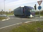 LKW SZM Mercedes-Benz Actros mit Pritsche-Planen-Auflieger der Spedition Pfeifer  Transporte im Kreisel vor dem Autohof in Grnstadt am 01.10.2013