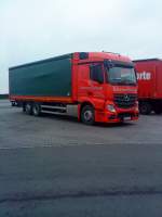 LKW Mercedes-Benz Actros 2545 mit Pritsche-Planen-Aufbau der Schreinerei Kuhaupt gesehen auf dem Parkplatz am Autohof Grnstadt am 03.02.2014