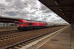 MEG-Lok 321, alias 077 012, ist am 30.04.18 wahrscheinlich auf dem Weg zum Zementwerk Rüdersdorf und durchfährt dabei den Flughafenbahnhof in Schönefeld.