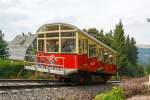 
Der Wagen 1 - Personenwagen der Standseilbahn der Oberweibacher Bergbahn befindet sich am 24.08.2013 auf Bergfahrt und erreicht gleich den Bergbahnhof Lichtenhain.
Der Personenwagen, im betrieblichen Umgang als Wagen 1 bezeichnet, ist seit der Erffnung 1923 nur an den Stirnseiten leicht verndert worden. Das erfolgte 1959, als er grere Stirnfenster erhielt und die leicht ausgestellte Stirnpartie. Bei der Rekonstruktion  2002 wurde die Fahrradbhne angebaut. Besonderheit, sie ist nur am Fahrgestell befestigt und kann 8 Fahrrder aufnehmen.

TECHNISCHE DATEN:
Lnge: 9,66 m (ohne Fahrradbhne)
Breite: 3,93 m (ohne Tritte und Haltestangen)
Hhe ber SO: 4,08 m (variiert wegen Federung)
Eigengewicht: 26 t
Nutzlast: 7,5 t
Sitzpltze: 42
Stehpltze: 58

Bergbahntechnik einer ganz besonderen Art:
Die Bergbahn besteht aus zwei Teilen:
- der Standseilbahn, von Obstfelderschmiede nach Lichtenhain und
- der  Flachstrecke  der Bergbahn, von Lichtenhain nach Cursdorf
Die Konzession zum Bau wurde fr eine Eisenbahnstrecke von Obstfelderschmiede nach Cursdorf erteilt, heute als Strecke Nr. 6691, KBS 563, der Deutschen Bahn AG gefhrt. Die Standseilbahn ist also ein Bestandteil dieser Eisenbahnstrecke.
Die Standseilbahn hat zwei unterschiedliche Fahrzeuge, einen “Personenwagen” und eine “Gterbhne” zum Transport normalspuriger Eisenbahnwagen bis 27 t Gesamtmasse.
Sie wurde gebaut fr den Gterverkehr, um die Hochebene um Oberweibach an das deutsche Eisenbahn-Netz anzuschlieen.
