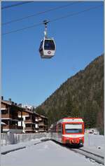 Der TMR Beh 4/8 71 erreicht sein Ziel Vallorcine, während hin der Höhe eine Gondle der Seilbahn vorüber schwebt.