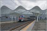 Ein FS Treniatalia ETR 103 der Tochtergesellschaft TPER (Transporto Passeggeri Emilia Romagna) ist als Regionalzug von Reggio S. Lazzaro nach Guastalla unterwegs und verlässt den Bahnhof Reggio Mediopadana. Im Hintergrund ist der imposante Bahnhof von Reggio Emilia AV zu erkennen. 

14. März 2023