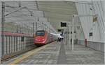 Während ein FS Trenitalia ETR 500 in der wunderschönen Halle des Bahnhofs von Reggio Emilia AV auf der Fahrt nach Norden kurz anhält; fährt kaum zu sehen links im Bild ein ETR 400