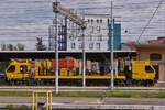 Mehrzweckfahrzeug OCPD 001, von Tesmec Rail, zur Wartung und Installieren von Oberleitungen mit Hilfe der an Bord installierten Spezialwerkzeuge, aufgenommen mit starkem Zoom, im Bahnhof von Verona Porta Nuova. Seitenansicht über mehrere Gleise Hinweg. 09.05.2025
