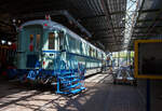 Der kombinierte Speise- und Gepäckwagen vom Typ Plan D – NS RD 7659 am 29 April 2025 im Het Spoorwegmuseum (bis 2005 NSM - Nederlands Spoorwegmuseum / Niederländischen Eisenbahnmuseum) in Utrecht im ehemaligen Bahnhof Maliebaan.

Der Halbgepäck-/Halbspeisewagen wurde 1951 von Beijnes, offiziell Koninklijke Fabriek van Rijtuigen en Spoorwagens J.J. Beijnes (Königliche Fabrik für Kutschen und Eisenbahnwagen J.J. Beijnes) in Haarlem gebaut und an die NS (Niederländische Eisenbahn) geliefert. Dieser Wagen wurde als RD 7659 und später ab 1966 als 51 84 87-40 111-0 geführt.

Der kombinierte Speise- und Gepäckwagen war 1951 eine Neuheit bei der NS. Die Wagentypen (Gattung) wurden kombiniert, da sowohl die einzelnen Speisewagen als auch die Gepäckwagen über erhebliche Kapazitätsüberschüsse verfügten. Aus betrieblicher Sicht war eine Kombination wirtschaftlicher. Die Serie dieser Plan D Wagen der Gattung WRD bestand aus 10 Stück (RD 7651-7660). Die NS setzte den kombinierten Wagen auch im internationalen Verkehr ein. 

An Bord befanden sich eine Bar und eine Kombüse. Die Kombüse enthielt einen Kohleofen, einen Kühlschrank, eine Spüle und Stauraum. Der Speiseraum bot Platz für 15 Passagiere. Der Wagen verfügte außerdem über ein Schaffnerabteil, eine Telefonzelle (Telefon war nie installiert) und einen Informationspoint (wo ebenfalls nie einer saß). 1954 wurde der Speiseraum auf 23 Sitzplätze erweitert. Dies ging auf Kosten der Bar und des Informationabteils. Die Telefonzelle blieb als leerer, abgeschlossener Raum bestehen. Im anderen Teil des Wagens befand sich ein großes, abschließbares Gepäckabteil. Der Waggon wurde speziell für die Ausstellung 'Tosti’s, Truffels en Treinen' im Juni 2020 wunderschön restauriert und erhielt dank von Spenden der BankGiro Lottery, der Stichting Goede Doelen Nh1816 (Nh1816 Charity Foundation) und des Vereins der Freunde des Eisenbahnmuseums seine ursprüngliche türkise Farbe zurück.

Die Plan D Wagen:
Plan D ist die Typenbezeichnung für eine Reihe von Reisezugwagen (D-Zug-Wagen) die zwischen 1950 und 1951 von den beiden Herstellern Werkspoor oder Beijnes gebaut wurden. Diese Wagen waren von 1950 bis 1987 bei den Niederländischen Eisenbahnen (NS) im Einsatz. 

Die NS beschloss 1949, ihren stark dezimierten Fuhrpark um siebzig D-Zugwagen zu ergänzen, die die Typenbezeichnung Plan D erhielten. Die Bestellung an Werkspoor und Beijnes umfasste zwanzig Wagen der ersten und zweiten Klasse (AB), vierzig Wagen der dritten Klasse (C) und zehn Wagen mit Speise- und Gepäckabteilen (RD), somit insgesamt 70 Wagen. 

Die Wagenkastenkonstruktion entsprach weitgehend den der Rundkopfwagen die zwischen 1935-1939 gebaut worden waren. Die Böden, die zuvor aus Holz bestanden, bestanden nun aus geripptem Blech mit Korkfüllung. Durch die Verwendung dieses gerippten Materials konnten verschiedene Querkonstruktionen entfallen. Auch die Drehgestelle waren anders konstruiert und orientierten sich an der Vorkriegsbauart „IT“, heute Bauart „S“.

Das Erscheinungsbild der Wagen veränderte sich durch zusätzliche Dachrinnen und elektrische Schlusslichter. Die zuvor verwendeten Schlusslichteisen blieben aufgrund ihres internationalen Einsatzes erhalten. Die Wagen hatten zudem ein Abteil weniger als die alten Rundkopfwagen.

Die Wagen wurden ab 1950 in der damals neuen türkisfarbenen Lackierung in Betrieb genommen. Gezogen von den ebenfalls neuen und in gleicher Farbe gelieferten Elektrolokomotiven der Baureihen 1100, 1200 und 1300 wurden sie für Schnellzüge eingesetzt. Nach einigen Jahren wurde das auffällige Türkis durch Berliner Blau ersetzt, das sie bis zuletzt behielten.

Mit Ausnahme der RDs wurden diese Wagen zwischen 1974 und 1978 ausgemustert. Aufgrund des gestiegenen Kapazitätsbedarfs auf der Strecke Amsterdam–Brüssel Anfang der 1970er Jahre wurden acht RDs nach einem erfolgreichen Probebetrieb 1974 zu Steuerwagen für Benelux-Züge im Wendezugbetrieb umgebaut. Diese Wagen dienten in dieser Funktion bis 1987, als sie durch neu gebaute Wagen in gelb-roter Lackierung nach dem ICR-Design ersetzt wurden.

Folgende Serien wurden gebaut:
20 Stück Serie AB 7701-7720 – mit 12 Sitzplätze in der 1. und 36 in der 2. Klasse
40 Stück Serie C 7801-7840 - mit 72 Sitzplätze in der 3. Klasse
10 Stück Serie RD 7651-7660 – mit 15 Sitzplätze im Restaurant (später 23)

TECHNISCHE DATEN:
Baujahr: 1950/51
Hersteller: Werkspoor oder Beijnes
Spurweite: 1.435 mm (Normalspur)
Achsen: 4 (in 2 Drehgestellen)
Achsfolge: 2'2'
Länge über Puffer: 22.650 mm
Drehzapfenabstand: 15.650
Achsabstand im Drehgestell: 3.000 mm
Leergewicht: 47 t (RD 48 t)
Sitzplätze: s.o.

Quellen: martijnhaman.nl, Somda RailWiki.nl, Het Spoorwegmuseum, nmld.nl, Anschriften, Wikipedia (Niederlande)
Stand/Überarbeitung: Oktober 2025