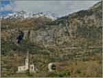 Im Vordergrund die Kirche von Raron und ganz oben auf den Berg ein BLS Ltschberger auf der Fahrt Richtung Bern.