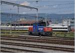 Die SBB Cargo Eem 923 015-2 steht vor dem Hintergrund eines in der Revision befindlichen ICN in Yverdon.