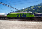 In Frutigen vor dem Lötschberg-Basistunnel wartet am 11 Juli 2022 die BLS Re 465 005, ex „Niesen“ (91 85 4465 005-7 CH-BLS) mit einem Kesselwagenzug auf Weiterfahrt, so konnte ich sie aus einem Zug aufnehmen.

Die Lok wurde 1994 von der SLM (Schweizerische Lokomotiv- und Maschinenfabrik) in Winterthur unter der Fabriknummer 5642 gebaut, der elektrische Teil ist von der ABB (Asea Brown Boveri).

Die Re 465 ist eine von der BLS Lötschbergbahn beschaffte elektrische, vierachsige Universallokomotive mit Umrichtertechnik. Sie ist eine Weiterentwicklung der Re 460 der SBB und gehört zur Lok-2000-Familie. Nach der Erstbestellung der BLS über acht Maschinen die 1994 gebaut wurden, folgten weitere 1997 zehn Loks (009–018) für den Huckepackkorridor. Diese Loks aus den 90er-Jahren sind für den Personen- wie für den Güterverkehr im Einsatz. Künftig werden sie auch beim Autoverlad und im Berner Oberland eingesetzt, nicht mehr im originalen Dunkelblau, sondern im leuchtenden BLS-Grün.

Die Re 465 stellen eine Weiterentwicklung der Re 460 dar. Wie diese hat sie GTO-Thyristoren als Ventile im Stromrichter und Drehstrom-Asynchronmotoren. Der Unterschied liegt in der Umrichteranlage. Im Fall der Re 460 besteht ein Traktionsstromrichter (in der Lok sind zwei Geräte verbaut, ein Gerät pro Drehgestell) aus zwei Vierquadrantenstellern, die den Zwischenkreis parallel versorgen, und einem Motor-Wechselrichter, der zwei Motoren parallel speist. Die Stromrichter der Re 465 gruppieren sich zu drei Vierquadrantenstellern parallel an einem Zwischenkreis mit zwei Wechselrichtern, je einen Motor im Drehgestell speisend. Somit lässt sich eine schleudernde Achse schneller und effektiver wieder in normalen Lauf bringen. Wurde bei der Entwicklung der Re 460 auf Dreipunkt-Stromrichter gesetzt, wurde im Gegensatz dazu die Re 465 mit Zweipunkt-Technik ausgestattet. Die Zwischenkreisspannung senkte man entsprechend von 3,5 kV (Re 460) auf 2,8 kV (Re 465). Zudem besitzt die Re 465 sechspolige Asynchron-Fahrmotoren (Re 460: vierpolige Asynchronmotoren). Daraus resultiert eine gegenüber der Re 460 erhöhte Dauerleistung von 6.270 kW (Stundenleistung von 7.000 kW).

Die Radsätze im Drehgestell stellen sich radial zum Gleisbogen ein.

Zudem war die Re 465 im Unterschied zur Re 460 mit der Vielfachsteuerung des Systems IIId und (mit Übergangskabel) BLS/BBC ausgerüstet. Diese erlaubte die Vielfachsteuerung zum Beispiel mit Re 4/4II, Re 4/4III, Re 6/6, Re 425 oder Ae 415, beim Refit wurde diese Vielfachsteuerung ausgebaut und dafür eine Vielfachsteuerung für TRAXX und Vectron-Loks eingebaut. 

Zwischen 2019 und 2022 durchliefen alle 18 Loks des Typs Re 465 ein Modernisierungsprogramm (Refit). Darin enthalten waren unter anderem der Einbau der Vielfachsteuerung ZMS für den Güterverkehr mit Traxx- und Vectron-Lokomotiven und ETB (Ethernet Train Backbone) für den Autoverlad am Lötschberg. Die Vielfachsteuerung des Systems IIId wurde ausgebaut, so ist die Vielfachsteuerung mit älteren Loks wie der Re 425 nicht mehr möglich. Die Kästen wurden saniert und neu in hellem BLS-Lindengrün mit blauem Logo lackiert. 

Mit diesem Refit verlängert sich die Lebensdauer der rund 25-jährigen Loks um weitere 15 Jahre. Sie sind neu bis ins Jahr 2040 einsetzbar. Die modernisierten Lokomotiven sind gut zu erkennen, sie sind neu grün lackiert werden damit zur auffälligen und klar ersichtlichen BLS-Markenbotschafterin. Das Modernisierungsprogramm kostete insgesamt rund 20 Millionen CHF. Modernisiert wurden alle Loks in der BLS-Werkstätte Bönigen. Im Zuge des Refits wurden alle Taufnamen und Bilder entfernt.

Im Personenverkehr zieht bzw. stößt die Re 465 die GoldenPass-Express-Züge zwischen Interlaken Ost und Zweisimmen, im Güterverkehr wird sie in Mehrfachtraktion mit anderen Loks (TRAXX und Vectron) eingesetzt. Die Loks werden ab Ende 2023 auch beim Autoverlad eingesetzt und ersetzen damit die braunen Loks des Typs Re 425. Damit kann die BLS auf eine Neubeschaffung verzichten.

TECHNISCHE DATEN:
Spurweite: 1.435 mm (Normalspur)
Achsformel: Bo’Bo’
Länge über Puffer: 18.500 mm
Drehzapfenabstand:11.000 mm
Achsstand im Drehgestell: 2.800 mm
Treibraddurchmesser: 1.100 mm (neu)
Höhe: 4.540 mm
Breite: 3.000 mm
Dienstmasse: 84 t
Höchstgeschwindigkeit: 230 km/h
Stundenleistung: 7.000 kW
Dauerleistung: 6.400 kW
Anfahrzugkraft: 300 kN
Stromsystem: Wechselstrom 15 kV 16,7 Hz

Quellen: BLS, Wikipedia und Anschriften
Stand/Überarbeitung: Oktober 2025