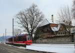 Berner Strassenbahnwagen 765 (Combino) auf der RBS (Regionalverkehr Bern-Solothurn) vor dem Gebudekomplex des Schlosses Muri, 21.Januar 2016.