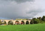 Die einstige MThB-Strecke zwischen Wil und Weinfelden: der gelbe Thurbo GTW 2/6 707 erscheint von Bussnang her auf dem grossen Viadukt.