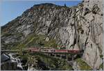 Der MGB Deh 4/4 N° 52 ist mit seinem Regionalzug kurz nach Andermatt auf dem Weg nach Göschenen und hat unweit der  Teufelsbrücke  die Reuss überquert.